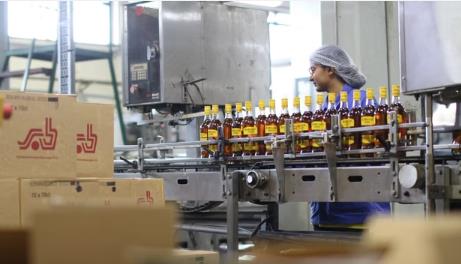 Medewerker met haarnet controleert de bottellijn bij SAB